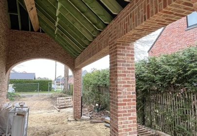 Overdekt terras met gemetselde kolommen en houten balken