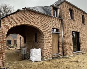 Nieuwbouwwoning in rode baksteen met een boogpoort