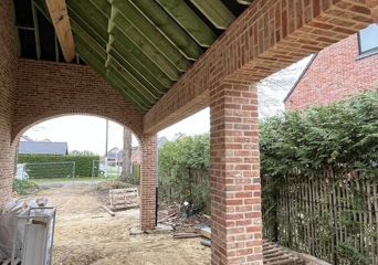 Overdekt terras met gemetselde kolommen en houten balken