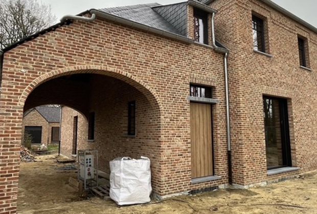 Nieuwbouwwoning in rode baksteen met een boogpoort